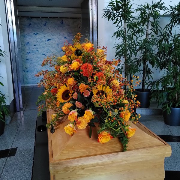 Sargschmuck mit herbstfarben mit Rosen, Sonnenblumen und Hagebutteranken Bild 3
